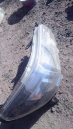 Used right headlight for Toyota Hilux GD6, clear lens with mounting points visible from front angle.Used right