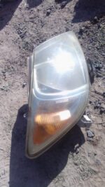 Right front headlight assembly for Toyota Hilux, used condition, shown angled facing left.Right front headligh