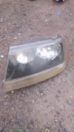 Left side used headlight assembly for Jeep Grand Cherokee shown from a front angle.Left side used headlight as