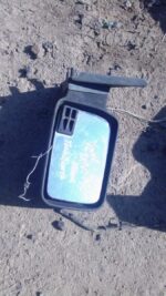 Right exterior side mirror for Ford Sierra shown angled, used condition visible with mounting bracket.Right ex