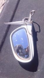 Used left side exterior mirror for 1997 Mazda 626, shown from an angled front view.Used left side exterior mir