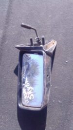 Left side car mirror for Nissan Skyline shown from front angle, used condition with visible wear.Left side car