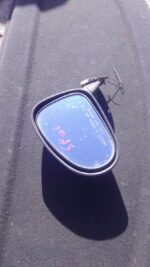 Left side mirror for Chevrolet Spark viewed from outside, used condition with visible mounting points.Left sid