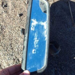 Rear view mirror for BMW E36, shown from front angle, used condition with intact mounting bracket.Rear view mi