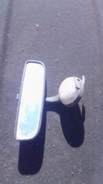 Used rear view mirror from a Hyundai Atos shown front-on with mounting bracket visible.Used rear view mirror f