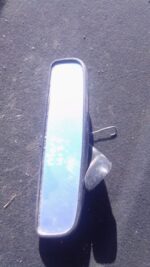 Used rear view mirror for Mercedes W123 shown from a front angle highlighting reflective surface and frame.Use