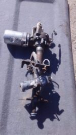 Used electric steering column for Nissan Micra, angled view showing wiring and mounting points.Used electric s