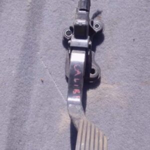 Used accelerator pedal for 2010 Dodge Caliber shown from side angle on white background.Used accelerator pedal