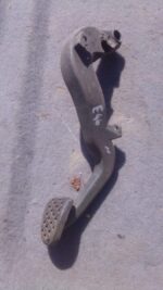 Used car brake pedal viewed from front showing pedal arm and pad on a clean white background.Used car brake pe