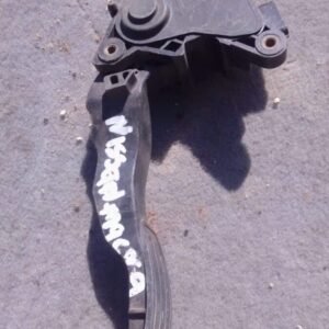 Used accelerator pedal for Nissan Micra, angled view showing mounting points and pedal surface.Used accelerato