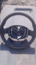 Front view of a used Renault Megane steering wheel showing the central hub, spokes, and grip sections.Front vi