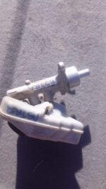 Used brake master cylinder for Opel Astra H, angled view showing mounting points and reservoir, slightly worn.