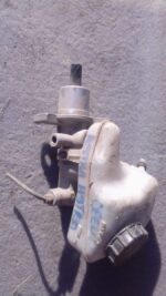 Front-angle view of a used brake master cylinder for a 2003 Opel Astra Classic on a plain background.Front-ang