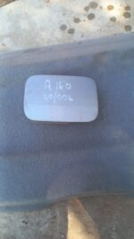 Used fuel flap for Mercedes A160 W168 shown from front angle against white background.Used fuel flap for Merce