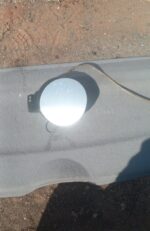Used fuel flap for Volkswagen Golf 5 shown from front angle, clean and intact surface.Used fuel flap for Volks