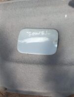 Close-up of a used BMW E36 fuel flap shown from a top angle against a white background.Close-up of a used BMW