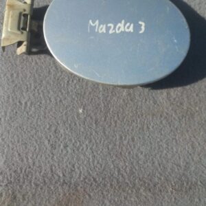 Used fuel flap for Mazda 3, shown flat against white background with slight shadow from top angle.Used fuel fl