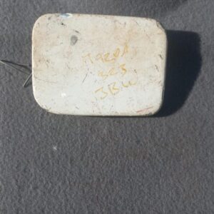 Used Mazda 323 fuel flap shown front-facing on a neutral background, suitable for replacement.Used Mazda 323 f