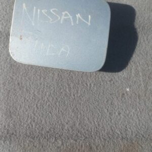 Used Nissan Tiida fuel flap shown from front angle with slight shadow on white background.Used Nissan Tiida fu