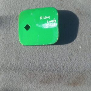 Used Nissan Langley fuel flap viewed from front, showing outer surface and hinge side.Used Nissan Langley fuel