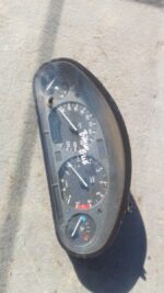 Front view of a used BMW E46 instrument cluster showing speedometer, tachometer, and warning lights.Front view