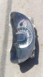 Front view of a used Nissan Micra instrument cluster with gauges and digital display panel.Front view of a use