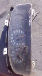 Front view of a used Mazda 626 instrument cluster showing speedometer and gauges.Front view of a used Mazda 62