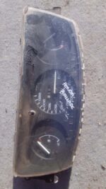 Front view of used car instrument cluster with speedometer and gauges, photographed on white background.Front