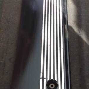Top-down view of a used black E39 engine cover with BMW logo and central circular intake opening.Top-down view