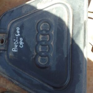 Front view of a used Audi 500 engine cover with mounting points and weathered surface details.Front view of a