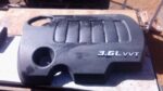 Front view of a used Dodge Journey engine cover showing mounting points and molded details.Front view of a use