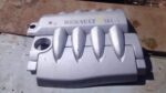 Top view of a used black engine cover for a 1.6 16v Renault Scenic, showing mounting points and recesses.Top v