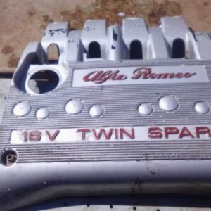 Top-down view of a used Twin Spark 16V engine cover showing the Alfa Romeo logo and mounting points.Top-down v