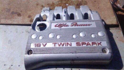 Alfa Romeo Twin Spark 16V Engine Cover - Used Top-down view of a used Twin Spark 16V engine cover showing the Alfa Romeo logo and mounting points.Top-down v