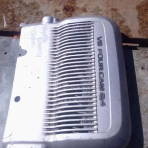 Front angle of a used 2.4L engine cover for a 1996 Toyota Camry, showing minor wear and mounting points.Front