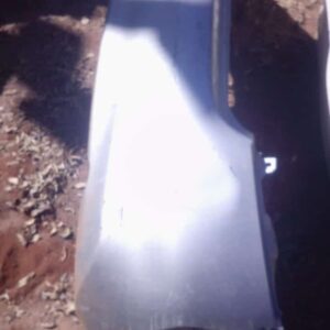 Rear view of used Nissan Almera rear bumper, showing full rear panel with mounting points visible.Rear view of