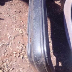 Rear view of a used rear bumper for a 2000 Toyota Corolla, showing mounting points and condition.Rear view of