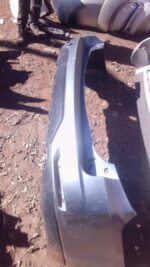 Rear view of used Nissan X-Trail rear bumper showing mounting points and surface condition.Rear view of used N