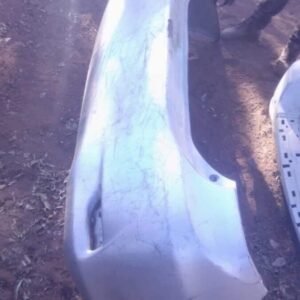 Used rear bumper of a 2013 Toyota Corolla, shown from a slightly angled front view on a white background.Used