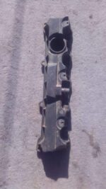 Front angled view of a used 1.6 16v tappet cover for Peugeot 206 with visible mounting points and gasket.Front