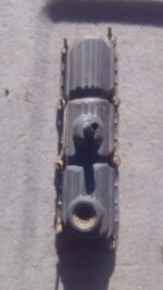 Left side view of a used Jeep Wrangler tappet cover showing mounting points and surface details.Left side view