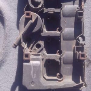 Front angled view of a used black tappet cover for Mercedes W203 engine on a white background.Front angled vie