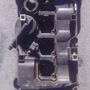 Top view of used Mercedes C180 engine tappet cover showing mounting holes and oil cap area.Top view of used Me
