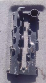 Front angle of a used 2.2 Tappet Cover for a 2010 TataTelcoline displayed on a wooden surface.Front angle of a
