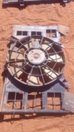 Used car radiator fan assembly angled front view with wiring and mounting points visible.Used car radiator fan