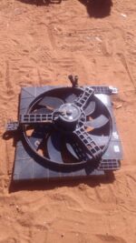 Front view of a used car radiator fan assembly with attached wiring harness, clean condition.Front view of a u