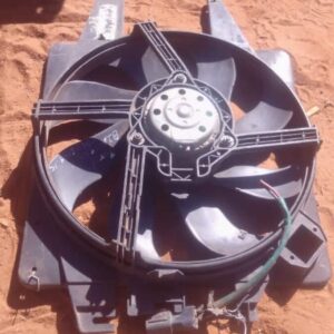 Used radiator fan installed on metal casing, viewed angled from front and side.Used radiator fan installed on