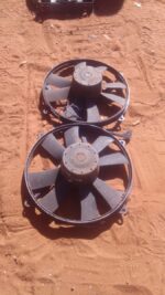 Front view of a used radiator fan assembly for a 1994 Mercedes W124, showing blades and housing side.Front vie