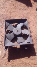 Front view of a used radiator fan assembly for a 2006 Chevrolet Optra, showing the fan blades and housing.Fron