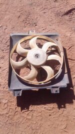 Front angle of used radiator fan assembly for 1.3 engine, showing blades and motor housing.Front angle of used